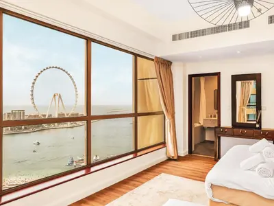 a bedroom with a large window with a view of the london eye at New! JBR Beachfront with Panoramic Dubai Eye Views in Dubai