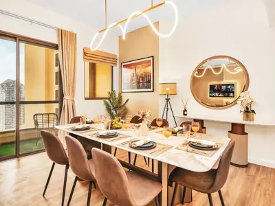 a dining room with a table and chairs and a mirror at New! JBR Beachfront with Panoramic Dubai Eye Views in Dubai
