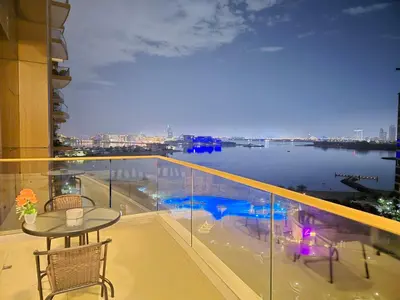 a balcony with a table and a view of the water at The Palm Panorama Chic Apartment with Open Sea Views Managed by SunnyHomes in Dubai