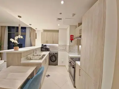 a kitchen with a sink and a dishwasher at The Palm Hideaway Chic Apartment with Rooftop Vibes Managed by SunnyHomes in Dubai