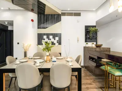 a dining room with a table and chairs and a piano at Luxurious 2BR Apt with Marina View & Private Jacuzzi in Dubai