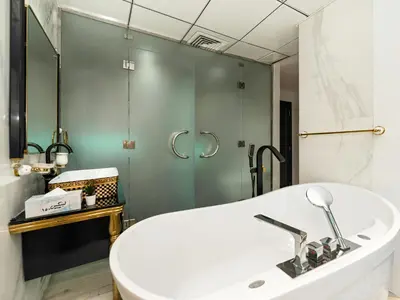 a bathroom with a white tub and a shower at Luxurious 2BR Apt with Marina View & Private Jacuzzi in Dubai
