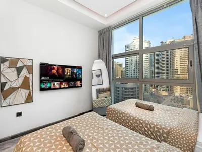 a bedroom with two beds and a large window at Luxurious 2BR Apt with Marina View & Private Jacuzzi in Dubai