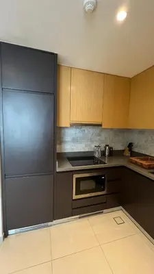 a kitchen with wooden cabinets and a stainless steel refrigerator at Private Apartment in Novotel JVT Comfort for 4 Guests in Dubai