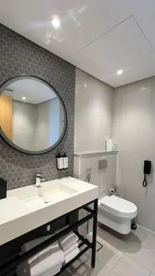 a bathroom with a sink and a toilet and a mirror at Private Apartment in Novotel JVT Comfort for 4 Guests in Dubai