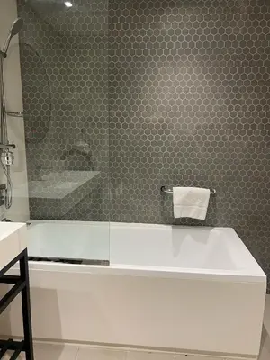 a bathroom with a tub and a shower and a mirror at Private Apartment in Novotel JVT Comfort for 4 Guests in Dubai
