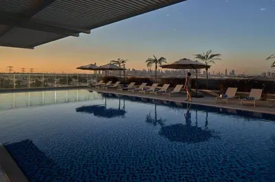a woman walks by a swimming pool at a hotel at Private Apartment in Novotel JVT Comfort for 4 Guests in Dubai