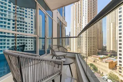 a balcony with a chair and a table and some buildings at Silkhaus Dubai Marina 1BR in Bay Central West Tower in Dubai
