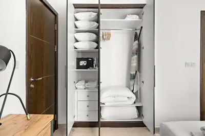 a walk in closet with white towels and a mirror at Silkhaus Dubai Marina 1BR in Bay Central West Tower in Dubai