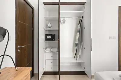 a bedroom with a closet with a glass door at Silkhaus Dubai Marina 1BR in Bay Central West Tower in Dubai