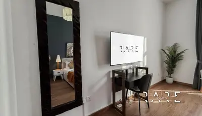 a mirror in a room with a table and a chair at Rare Holiday Homes - Mediterranean Cluster - Near Ibn Battuta Mall - Discovery Garden - Building# Med 38 - RG04 in Dubai