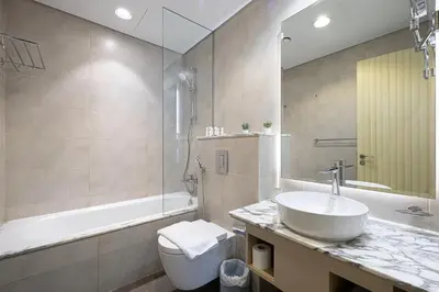 a bathroom with a sink and a tub and a toilet at Sky Suite 1 Bedroom Apartment with Infinity Rooftop Pool and Dubais Ultimate Skyline View at Paramount Midtown in Dubai