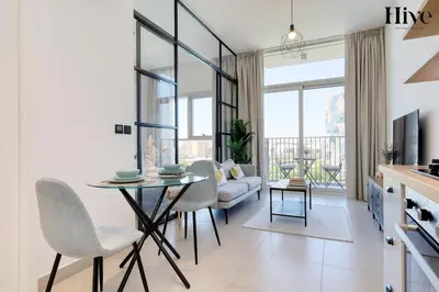 a kitchen and living room with a table and chairs at Cosy 1 bed Apt in Dubai Hills in Dubai