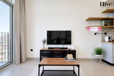 a living room with a tv and a coffee table at Cosy 1 bed Apt in Dubai Hills in Dubai