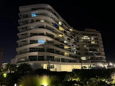 a large white building at night at Cozy Home with Beach Access in Palm Jumeirah in Dubai