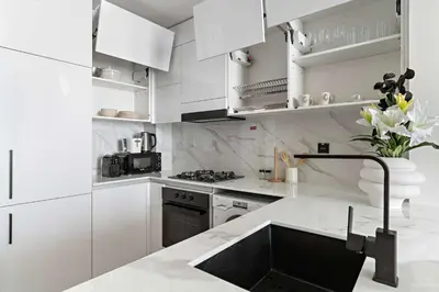 a white kitchen with white cabinets and a sink at Silkhaus Classic 1BDR Apartment in Binghatti House in Dubai
