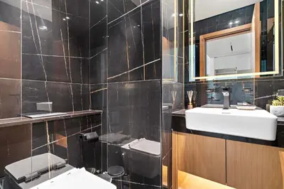 a black tiled bathroom with two sinks and a mirror at Silkhaus Classic 1BDR Apartment in Binghatti House in Dubai