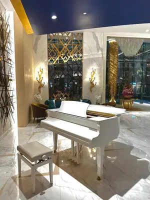 a white piano and a stool in a room at Luxury Studio Apartment in Downtown Dubai in Dubai