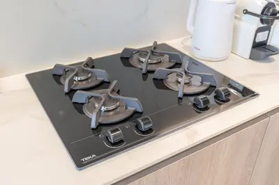 a black stove top on top of a kitchen counter at Luxury Stay JVC Modern 1BHK Pool & Gym Access in Dubai