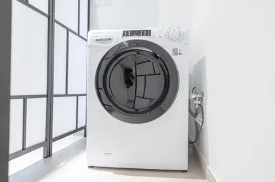 a washing machine in a room with a window at Luxury Stay JVC Modern 1BHK Pool & Gym Access in Dubai