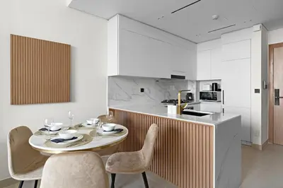 a dining room with a table and chairs and a kitchen at FIRST CLASS 1BR Cozy Urban Getaway in Dubai