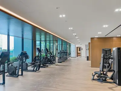 a gym with a row of treadmills and ellipticals at FIRST CLASS 1BR Cozy Urban Getaway in Dubai
