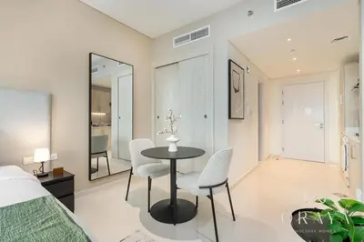 a bedroom with a table and chairs and a bed at Luxurious Studio In Seven Palm - Direct Beach Access in Dubai