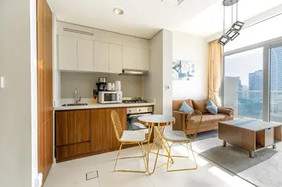 a kitchen and living room with a table and chairs at Full burj khalifa view 1bhk app in Dubai