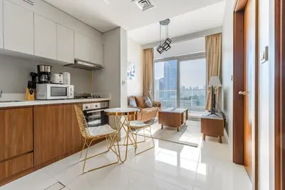 a kitchen with a counter and a table and chairs at Full burj khalifa view 1bhk app in Dubai