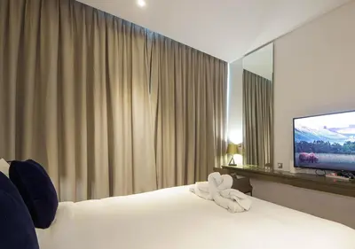 a hotel room with a bed and a flat screen tv at Waterfront Studio with Balcony Near Dubai Mall in Dubai