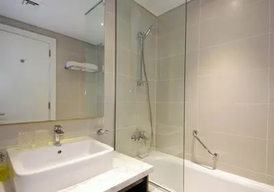 a bathroom with a shower and a sink and a tub at Waterfront Studio with Balcony Near Dubai Mall in Dubai