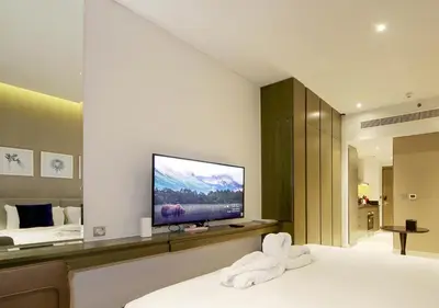 a bedroom with a bed with a flat screen tv at Waterfront Studio with Balcony Near Dubai Mall in Dubai