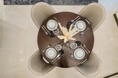a wooden table with plates and utensils on it at Spacious & Elegant 1BD, for 2 in Nobles tower in Dubai
