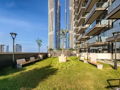 a building with a yard with benches in front of it at Spacious & Elegant 1BD, for 2 in Nobles tower in Dubai