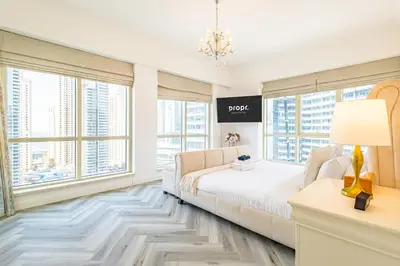 a bedroom with a bed and large windows at Serene 2BR Escape - Al Majara - Waterfront Stay in Dubai