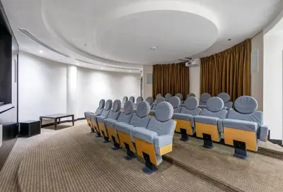 a conference room with blue chairs and a television at Serene 2BR Escape - Al Majara - Waterfront Stay in Dubai