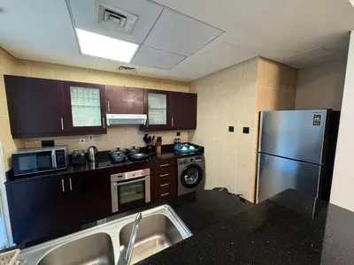 a kitchen with a stainless steel refrigerator and a sink at Holiday Homes by DO - Dubai Marina in Dubai
