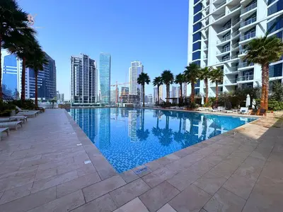 a large swimming pool with palm trees and buildings at Bellaviu Holiday Homes- Escape the Buzz-Your Quiet Spot in DAMAC Prive in Dubai