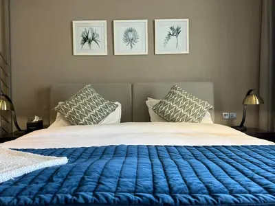 a bed with a blue blanket and two pillows at Bellaviu Holiday Homes- Escape the Buzz-Your Quiet Spot in DAMAC Prive in Dubai