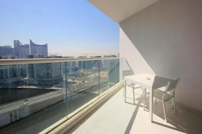 a balcony with a table and a view of a city at Stylish Studio Apartment with pool in Business Bay in Dubai