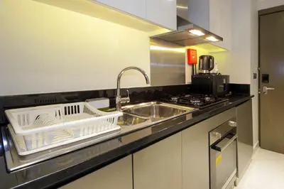 a kitchen with a sink and a stove and a dish rack at Stylish Studio Apartment with pool in Business Bay in Dubai