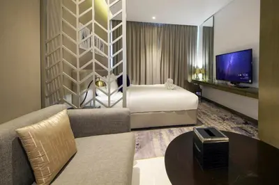 a hotel room with a bed and a tv at Stylish Studio Apartment with pool in Business Bay in Dubai