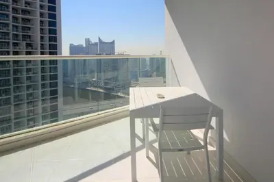 a white table and chair on a balcony with a view at Stylish Studio Apartment with pool in Business Bay in Dubai