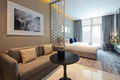 a living room with a couch and a bed at Stylish Studio Apartment with pool in Business Bay in Dubai