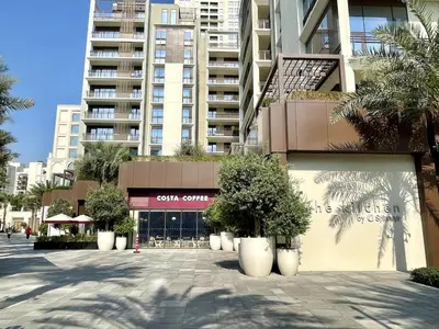 a building with trees in pots in front of a building at Sunset Creek Harbour, Dubai in Dubai
