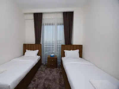 two twin beds in a room with a window at Sunset Creek Harbour, Dubai in Dubai