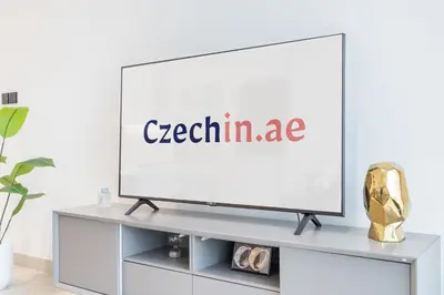 a flat screen tv on a tv stand in a living room at Stylish 1BHK by CzechIn Pool & Gym Prime JVC in Dubai