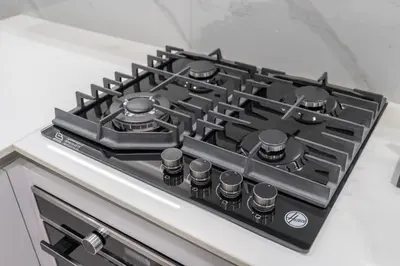 a black stove top oven sitting on top of a counter at Stylish 1BHK by CzechIn Pool & Gym Prime JVC in Dubai