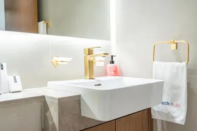 a white bathroom with a sink and a mirror at Stylish 1BHK by CzechIn Pool & Gym Prime JVC in Dubai