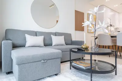 a living room with a couch and a table at Stylish 1BHK by CzechIn Pool & Gym Prime JVC in Dubai